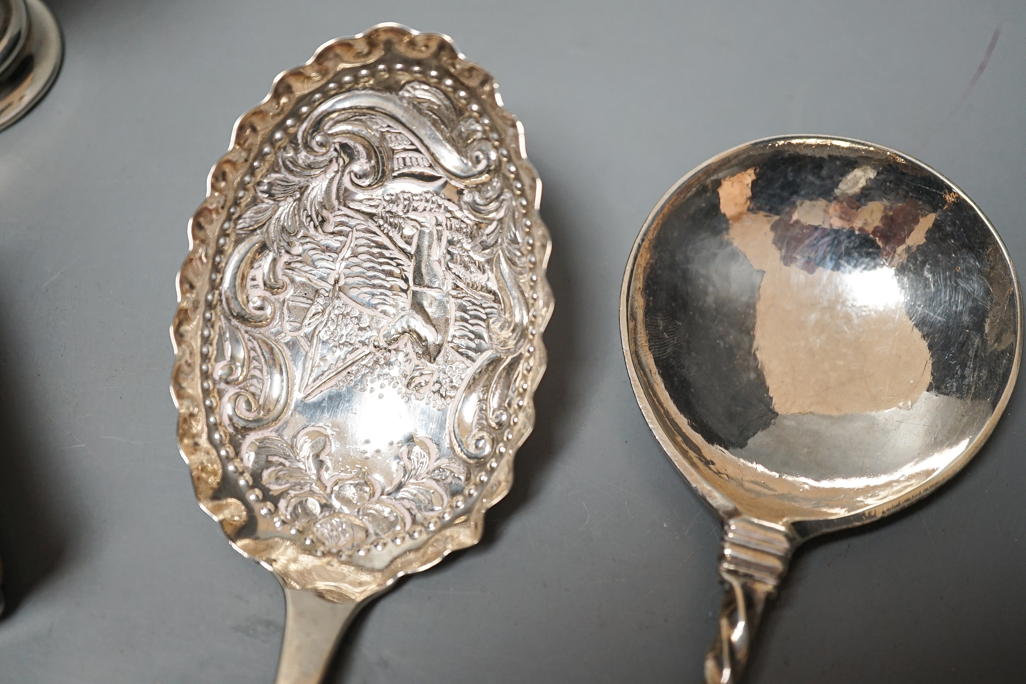 A 19th century Dutch embossed white metal spoon, 13.5cm, one other unmarked white metal spoon, a small silver posy vase and a repousse silver match sleeve.